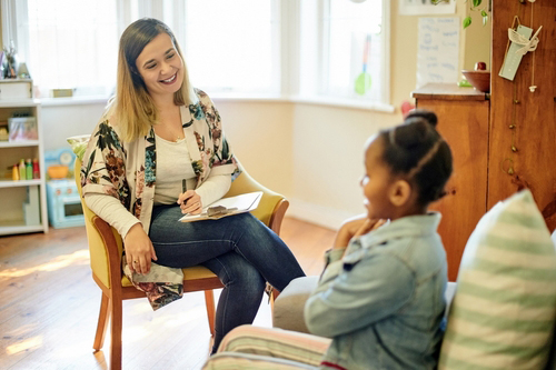 Child sitting with pediatrician during behavioral health evaluation session